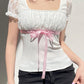 Top patchwork in pizzo bianco con fiocco Y2K e maniche a palloncino