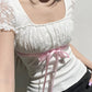 Top patchwork in pizzo bianco con fiocco Y2K e maniche a palloncino