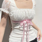 Top patchwork in pizzo bianco con fiocco Y2K e maniche a palloncino