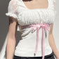 Top patchwork in pizzo bianco con fiocco Y2K e maniche a palloncino